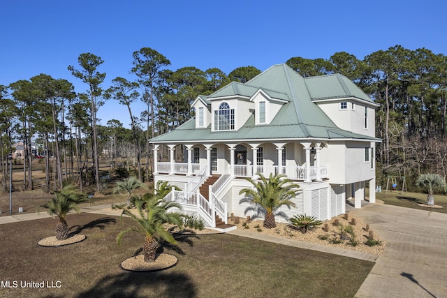 coastal home featuring concrete driveway, metal roof, a porch, stairway, and a carport
