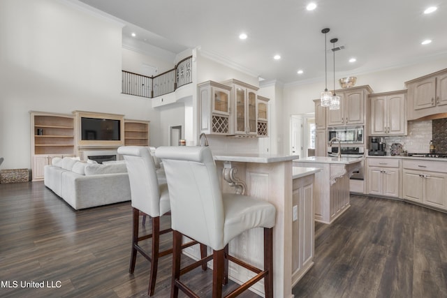 kitchen with appliances with stainless steel finishes, a breakfast bar area, recessed lighting, ornamental molding, and glass insert cabinets