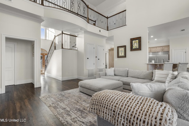 living area with baseboards, ornamental molding, a high ceiling, stairs, and dark wood-type flooring