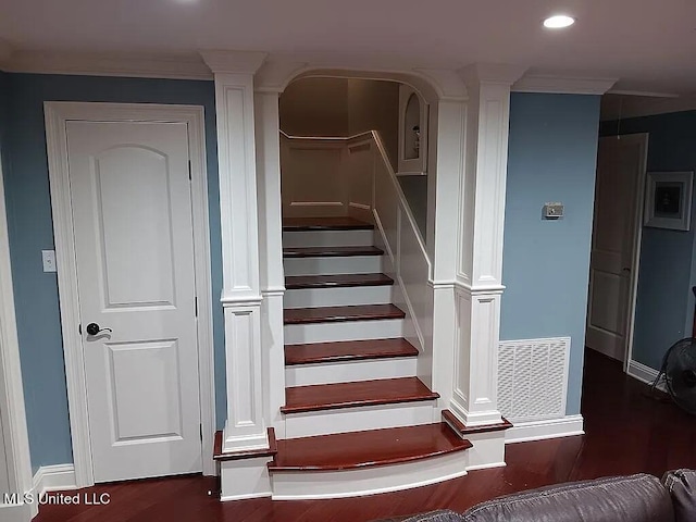 stairway with hardwood / wood-style floors, crown molding, and decorative columns