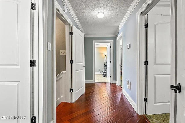 hallway featuring crown molding, a textured ceiling, and dark hardwood / wood-style floors