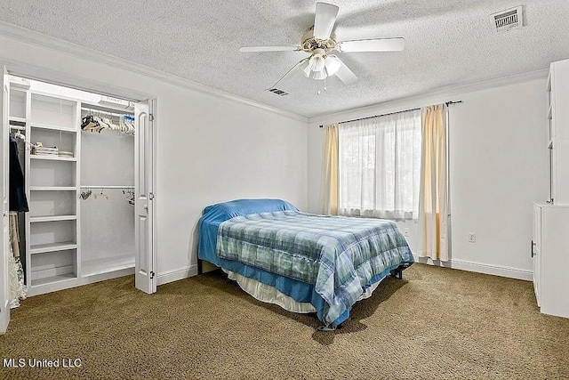 bedroom with crown molding, a textured ceiling, dark carpet, and ceiling fan