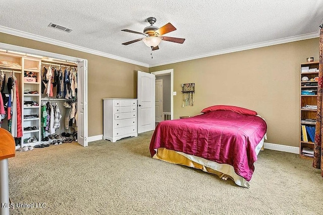 carpeted bedroom with a closet, a textured ceiling, crown molding, and ceiling fan