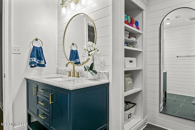 bathroom with vanity and wooden walls