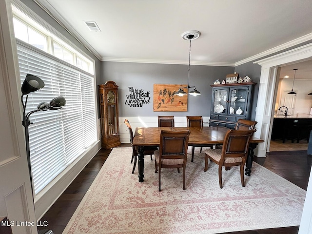 dining area with dark hardwood / wood-style flooring and crown molding