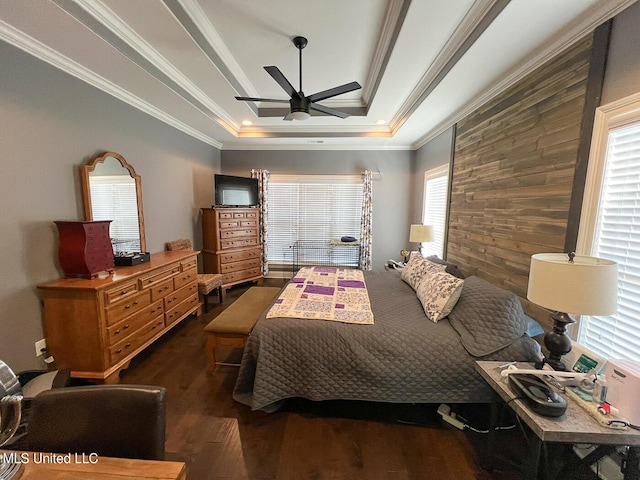 bedroom featuring a tray ceiling, crown molding, dark hardwood / wood-style flooring, and ceiling fan