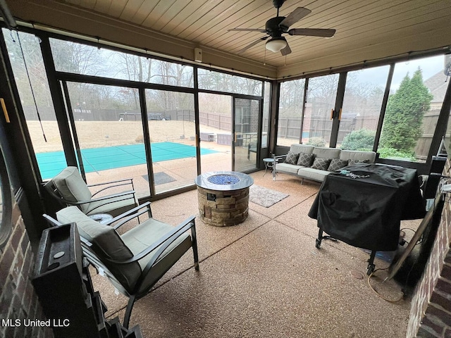 sunroom / solarium featuring wooden ceiling and ceiling fan