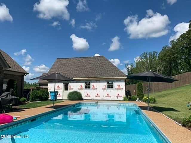 view of pool featuring an outbuilding and a lawn