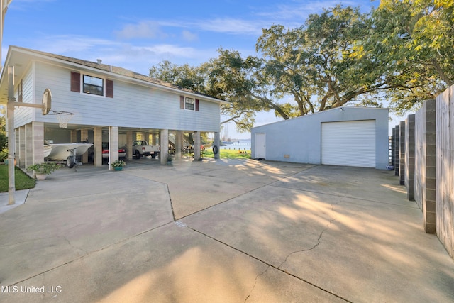 back of house with an outbuilding, a garage, and a carport