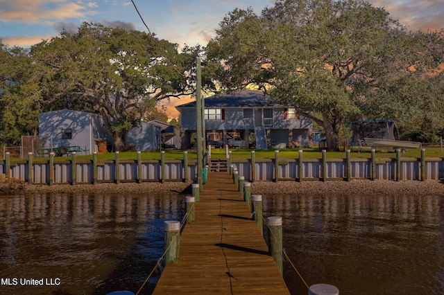 dock area with a lawn and a water view