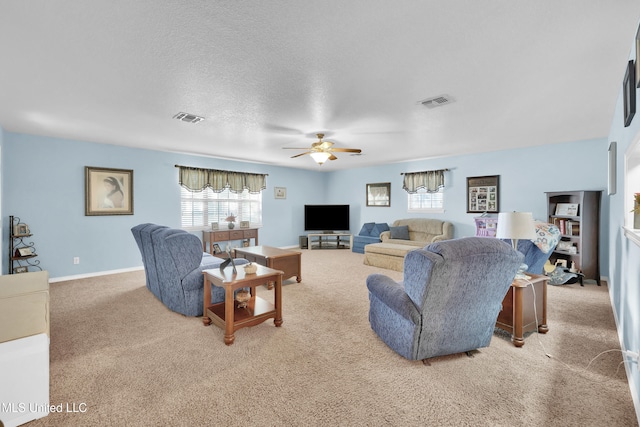 carpeted living room featuring a textured ceiling and ceiling fan