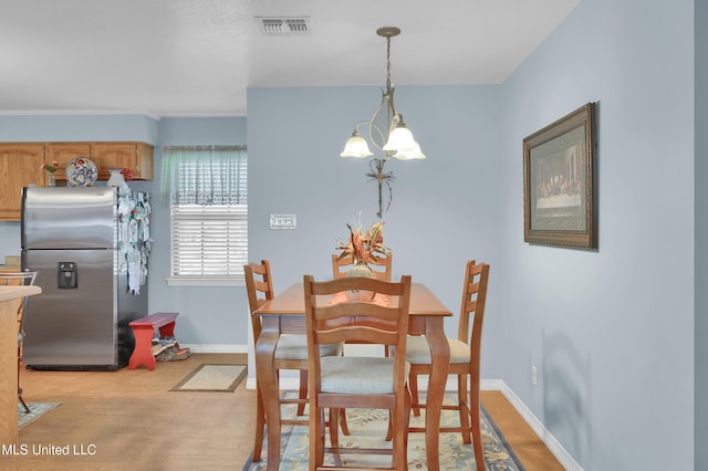 dining room featuring a notable chandelier and light wood-type flooring