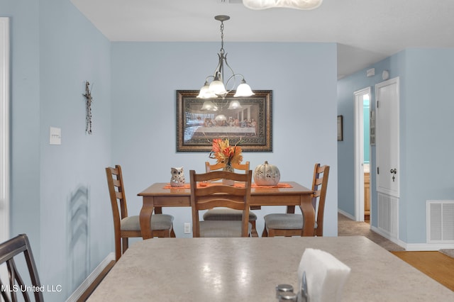 dining room featuring wood-type flooring and a chandelier