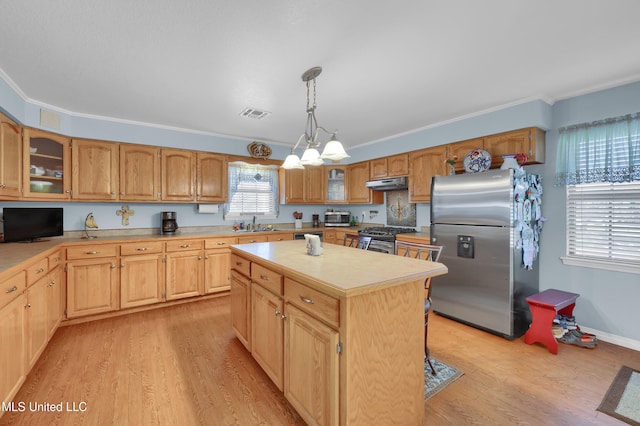 kitchen with a center island, crown molding, and appliances with stainless steel finishes