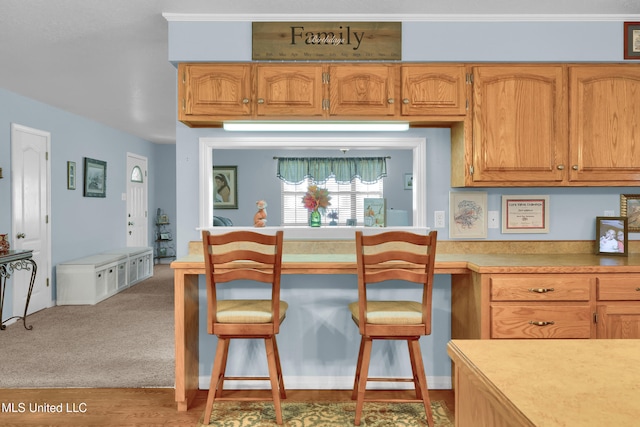 kitchen featuring ornamental molding and light hardwood / wood-style flooring