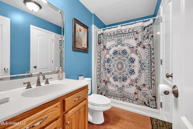 bathroom with vanity, wood-type flooring, a textured ceiling, and toilet