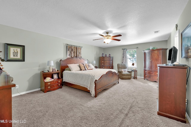 carpeted bedroom featuring ceiling fan and a textured ceiling