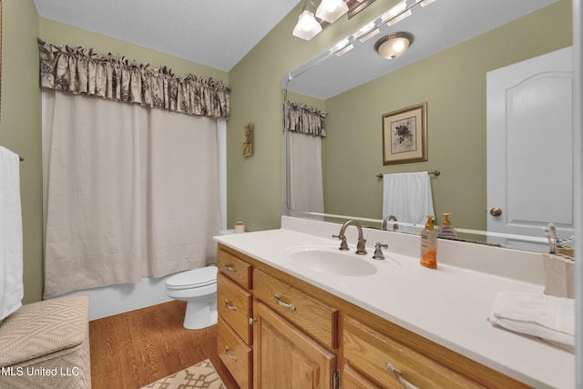 full bathroom with hardwood / wood-style floors, vanity, shower / bath combination with curtain, and toilet