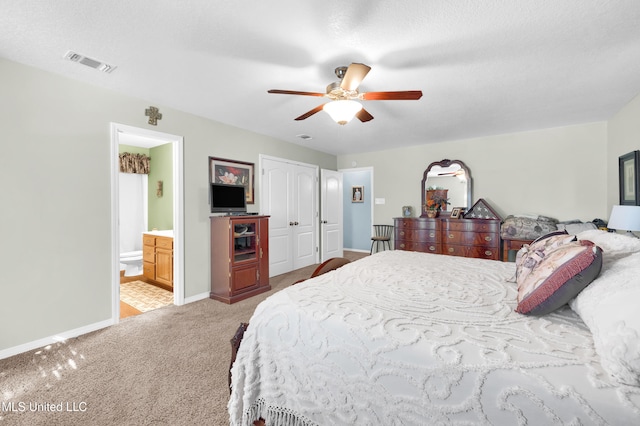 carpeted bedroom featuring connected bathroom, ceiling fan, a closet, and a textured ceiling