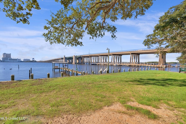 dock area with a lawn and a water view