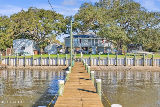 view of dock featuring a water view and a yard