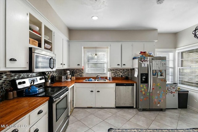 kitchen featuring appliances with stainless steel finishes, white cabinetry, plenty of natural light, and sink