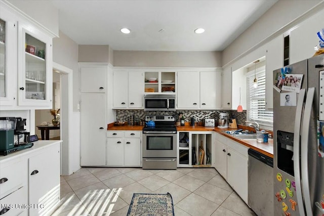 kitchen with white cabinets, light tile patterned floors, sink, and appliances with stainless steel finishes