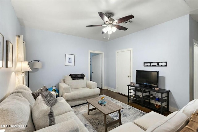 living room featuring ceiling fan and dark wood-type flooring