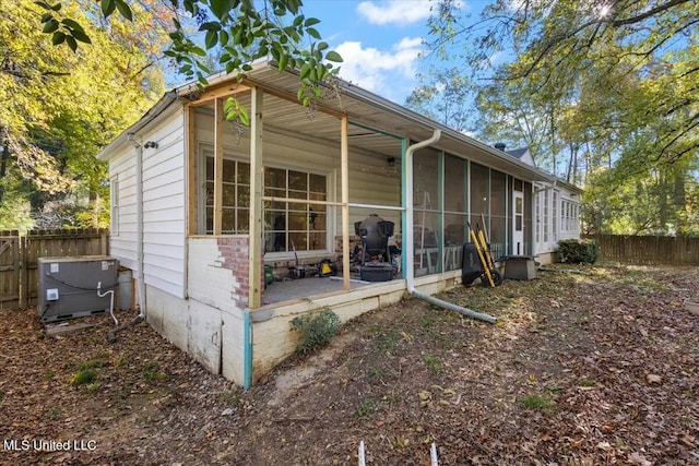 back of property with a sunroom and cooling unit