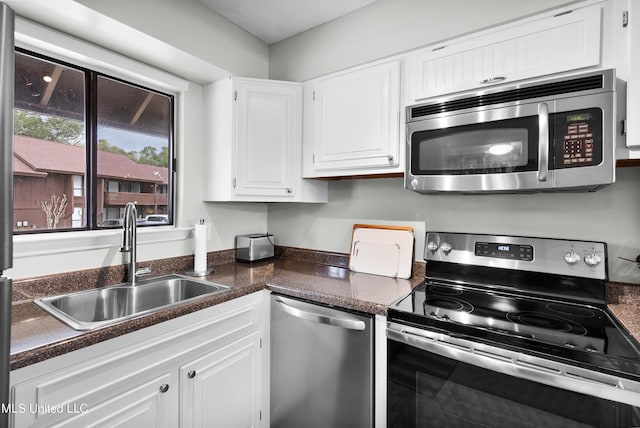 kitchen with stainless steel appliances, sink, and white cabinets