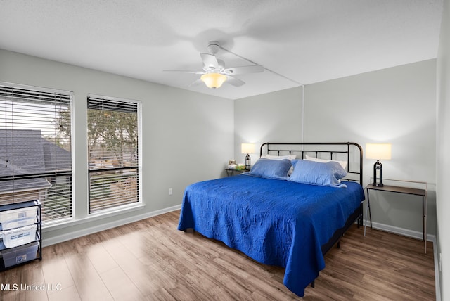 bedroom with hardwood / wood-style floors, a textured ceiling, and ceiling fan