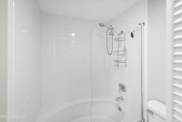 bathroom with toilet and tiled shower / bath combo