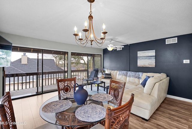 dining space with hardwood / wood-style floors and an inviting chandelier