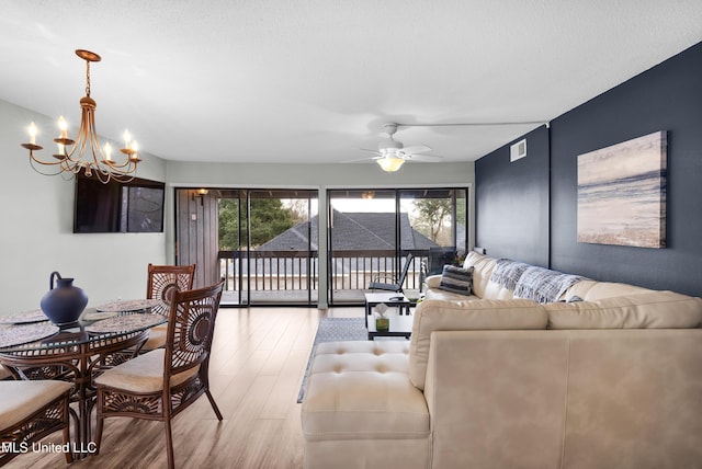 living room featuring wood-type flooring and ceiling fan with notable chandelier