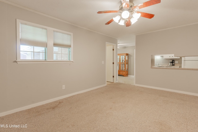 spare room with light carpet, crown molding, and ceiling fan