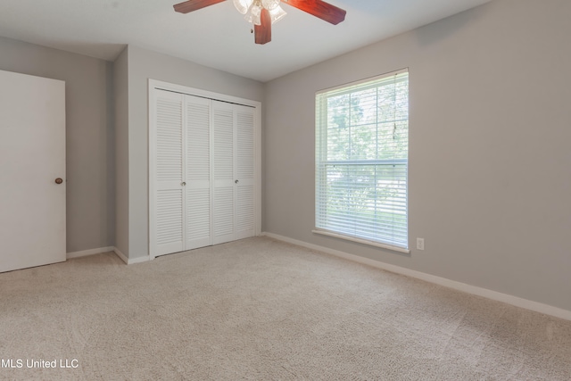 unfurnished bedroom with light carpet, a closet, and ceiling fan