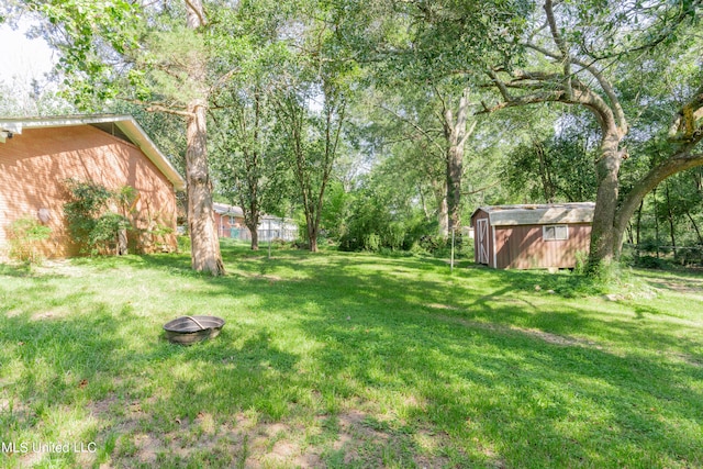 view of yard with a storage shed and an outdoor fire pit