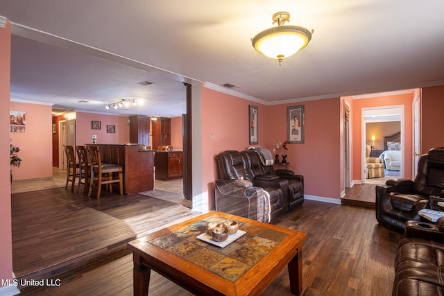 living room featuring crown molding, bar, and dark wood-type flooring