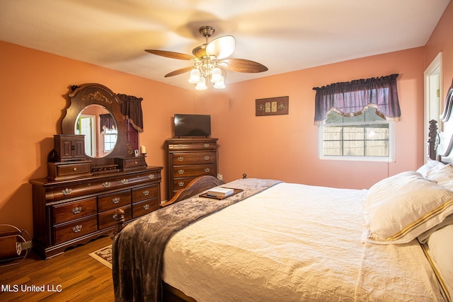 bedroom with dark hardwood / wood-style flooring and ceiling fan