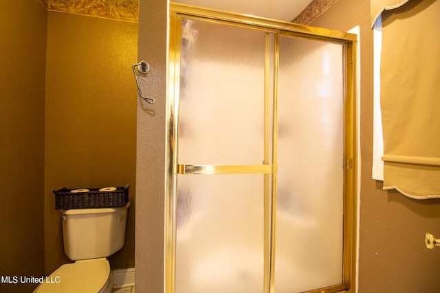 bathroom with toilet and an enclosed shower