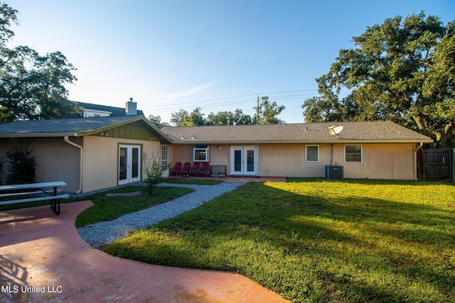 view of front of property with french doors, a front yard, and cooling unit