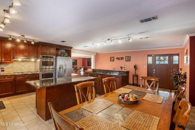 dining room featuring crown molding and light tile patterned flooring