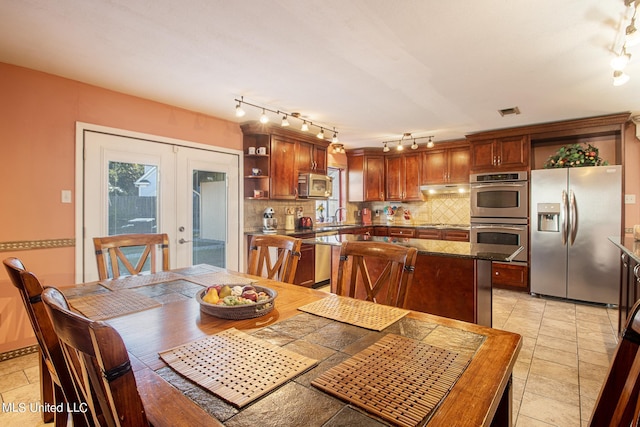 dining space featuring french doors, sink, and track lighting