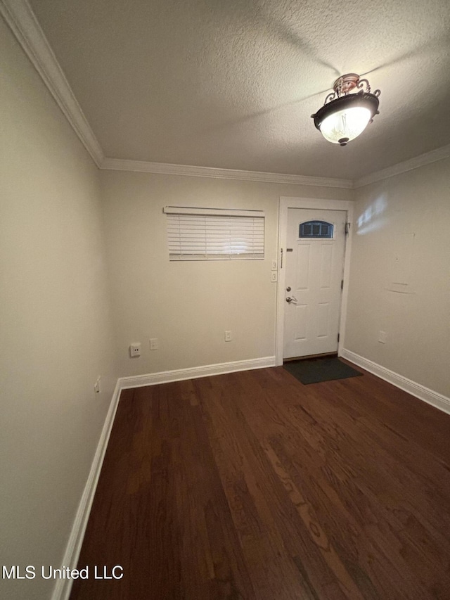 foyer entrance with a textured ceiling, dark hardwood / wood-style flooring, and crown molding