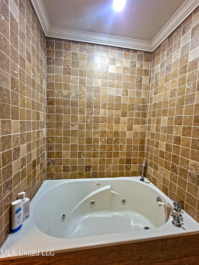 bathroom with a bathing tub, a textured ceiling, and ornamental molding