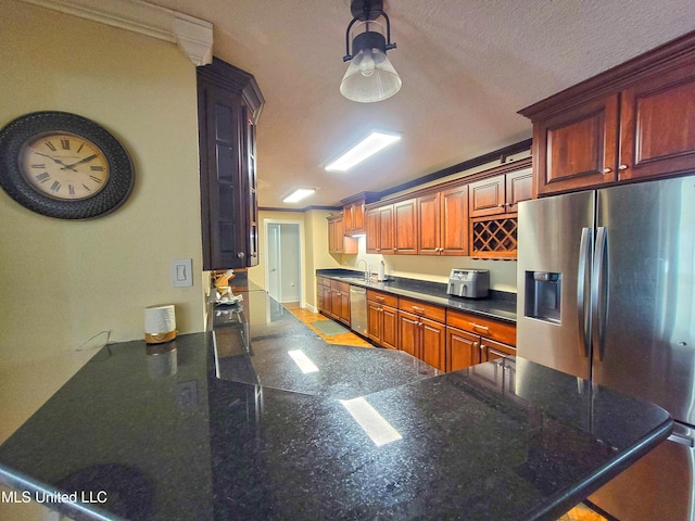 kitchen featuring sink, stainless steel appliances, kitchen peninsula, crown molding, and a textured ceiling