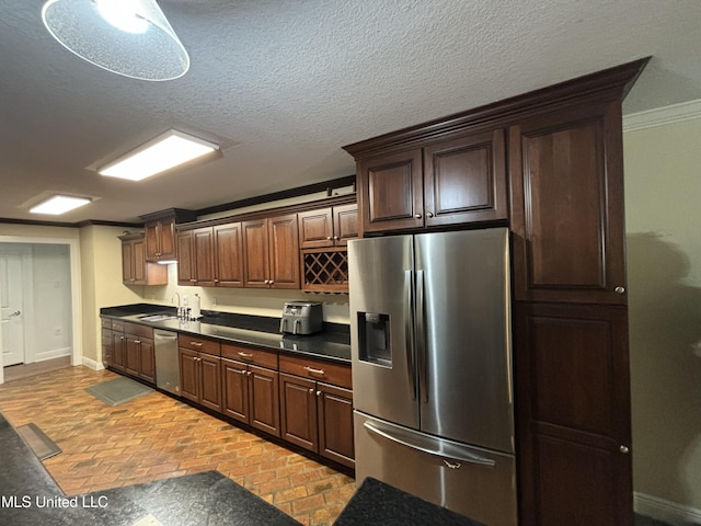 kitchen featuring crown molding, sink, a textured ceiling, and appliances with stainless steel finishes