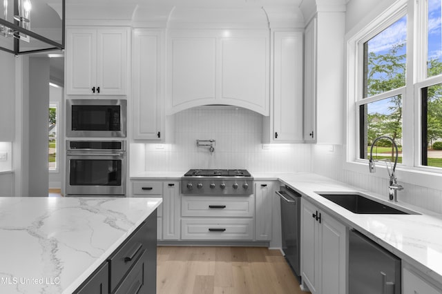 231 Oakside Trl, Madison, MS 39110 - kitchen with stainless steel appliances, a sink, light wood-style flooring, decorative backsplash, and white cabinets
