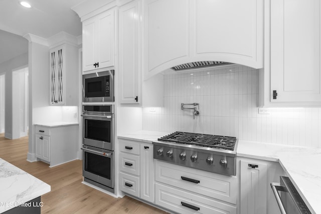 231 Oakside Trl, Madison, MS 39110 - kitchen featuring stainless steel appliances, white cabinets, tasteful backsplash, light wood-style floors, and light stone countertops