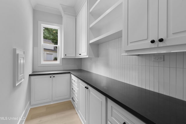 231 Oakside Trl, Madison, MS 39110 - kitchen with dark countertops, decorative backsplash, white cabinetry, light wood finished floors, and baseboards